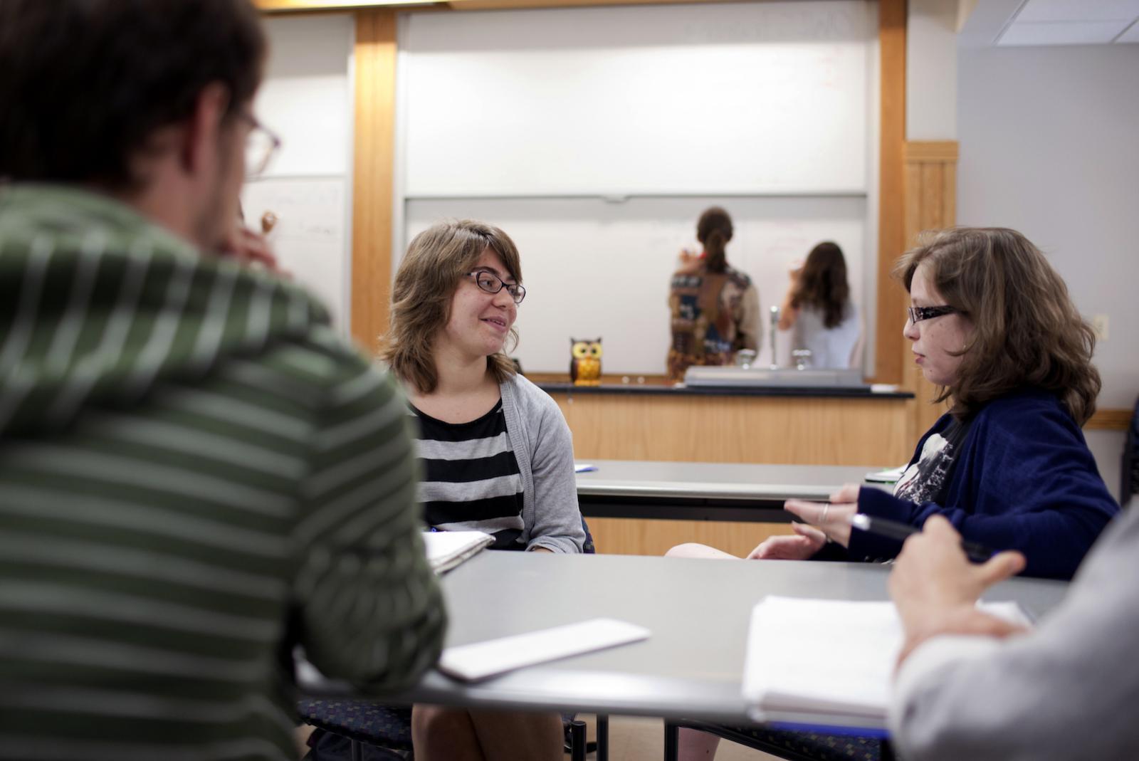 students at a table talking to each other